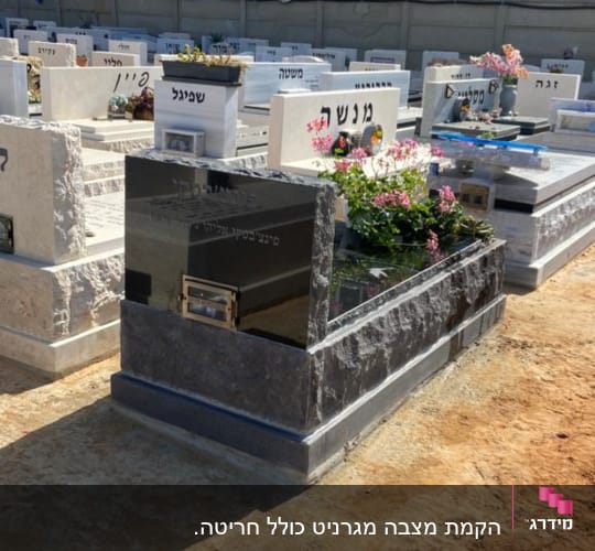 מצבות עם פרחים ואדמה מסביב בבית קברות